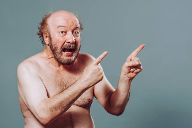 istock Front view senior man stand left looking at camera pointing index fingers right mouth say wow 2149683141