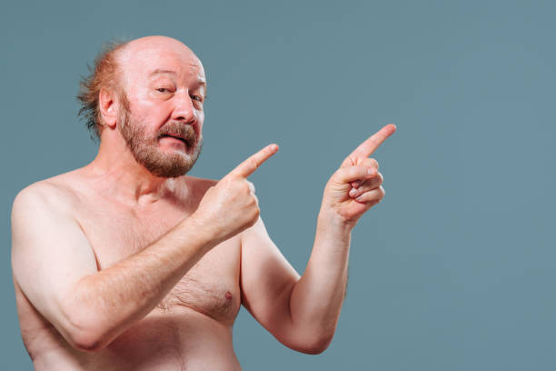 istock Front view senior man stand left looking at camera pointing index fingers right mouth say wow 2149683147