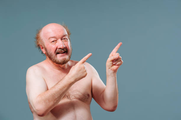 istock Front view elderly man stand from left looking to left pointing right index fingers of both hands. 2149683148