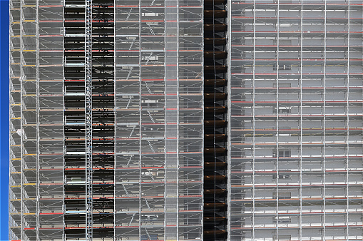 detail of the scaffolding of the façade of a skyscraper during maintenance to install the thermal insulation for energy saving without people