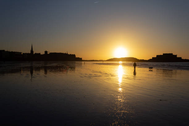 Walk on a beach of Saint-Malo at sunset time (Brittany, France)