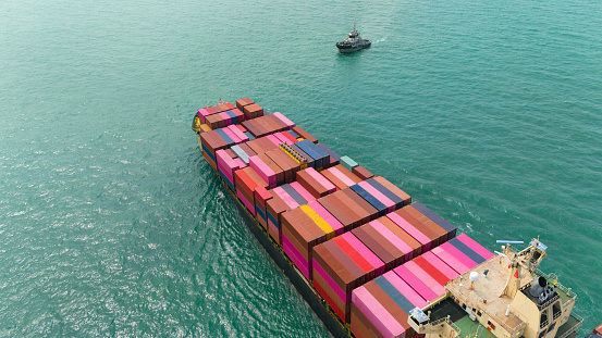 Container ship full speed sailing in sea for transporting cargo logistic import and export goods internationally around the world, including Asia Pacific and Europe, Aerial view photograp from drone