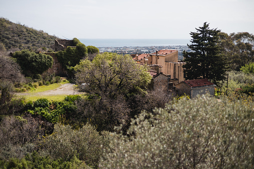 Alassio, Italy - March 31, 2024: Picturesque breathtaking view from the heights of the mountains - the wealth of nature and buildings of medieval architecture in the distance - an abandoned castle
