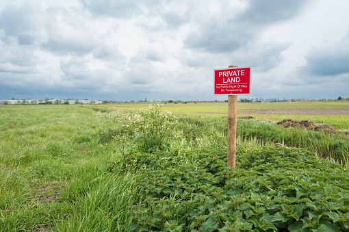 Shallow focus of a newly erected Private Land sign at the entrance to a large arable field in the East of England. The land has had illegal activity.