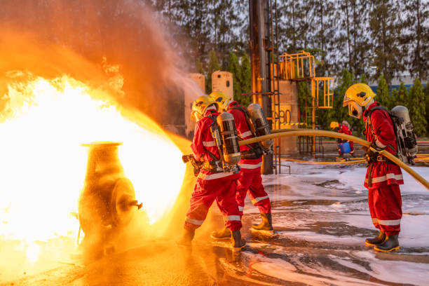 istock Firefighters Controlling Flame with Foam Spray at Dusk 2149685463