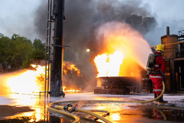istock Firefighters Controlling Flame with Foam Spray at Dusk 2149685509
