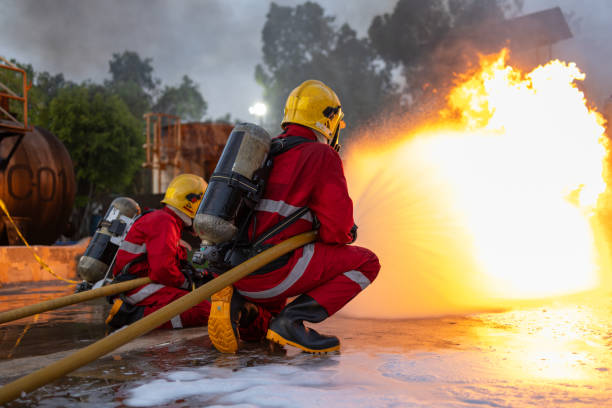 istock Firefighters Controlling Flame with Foam Spray at Dusk 2149685519