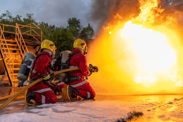 istock Firefighters Controlling Flame with Foam Spray at Dusk 2149685589