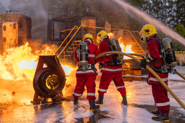 istock Firefighters Controlling Flame with Foam Spray at Dusk 2149685630