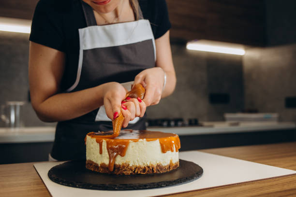 istock confectioner pours caramel cake in a modern kitchen 2149686705
