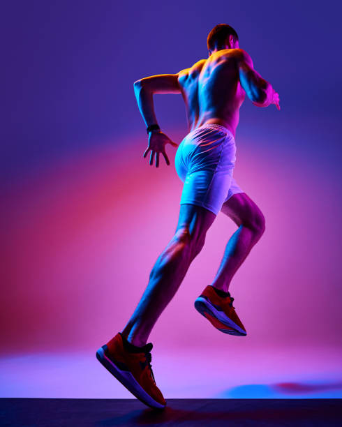 istock Bottom view of muscular, athletic young man training shirtless, running on gradient pink purple background in neon light 2149687904