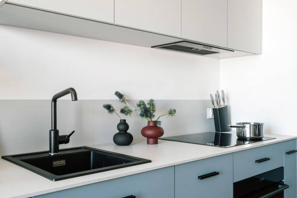 istock Glass ceramic hob, range hood, granite sink and black faucet at modern kitchen 2149688099