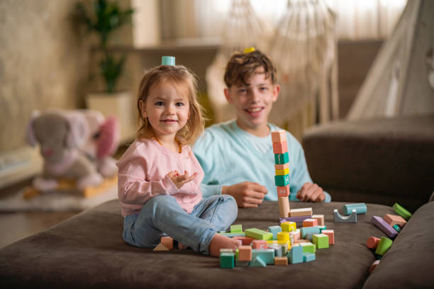 istock Boy and little girl having fun whit toy blocks 2149690553