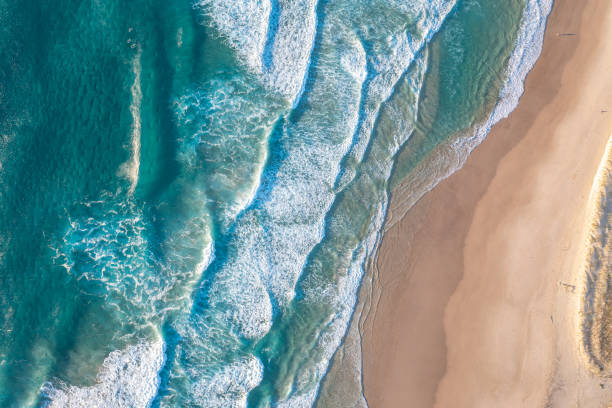 istock Patterned foamy ocean waves roll in and approach sandy beach. Majesty turquoise sea. Top view drone. 2149691285