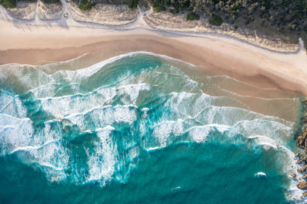 istock Foamy ocean waves roll and approach sandy beach. Majesty turquoise seascape. Top view from a drone. 2149691310