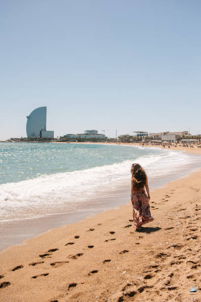 A young woman walking by the sea in Barcelona