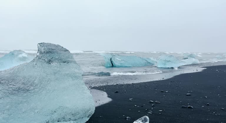 Ice cold sea water splash black sand Diamond Beach in Iceland in slow moiton