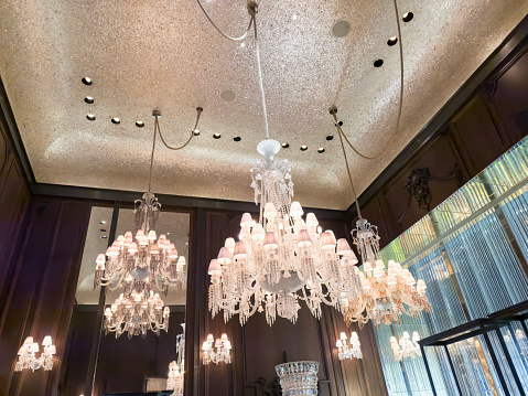 A low angle shot of a crystal chandelier hanging on a ceiling in a room