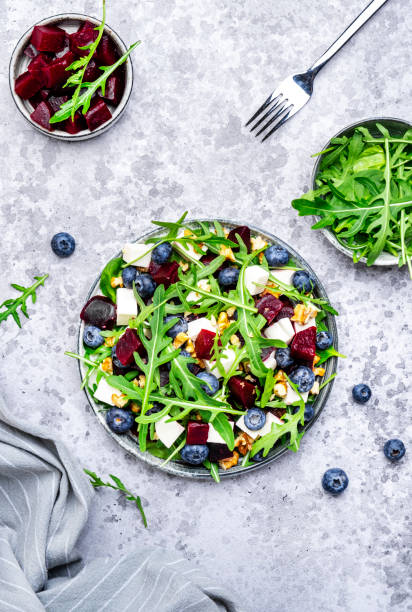 istock Healthy useful salad with beetroot, blueberries, feta cheese, arugula and walnuts, gray table background, top view 2149693715