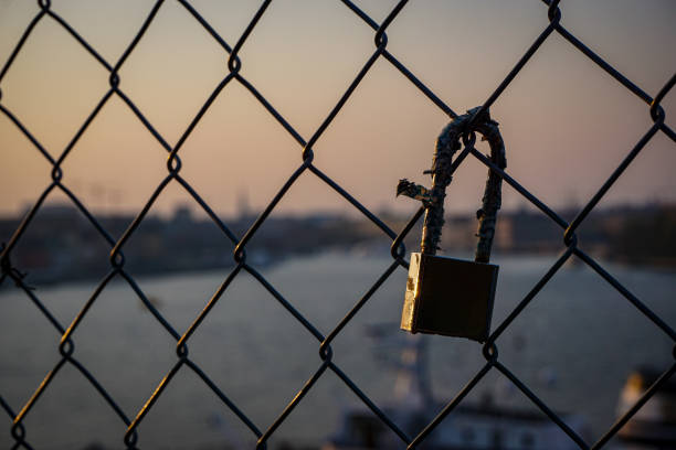 Close up of a padlock hanging on a fence