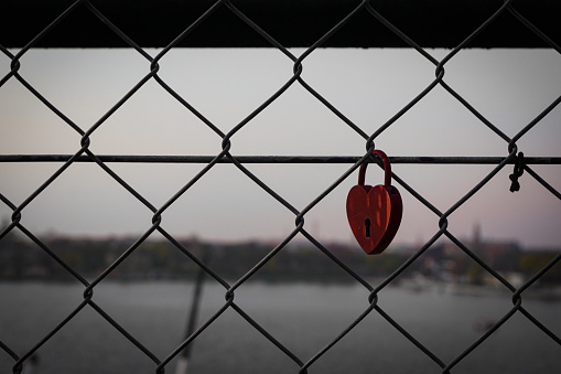 Close up of a padlock hanging on a fence