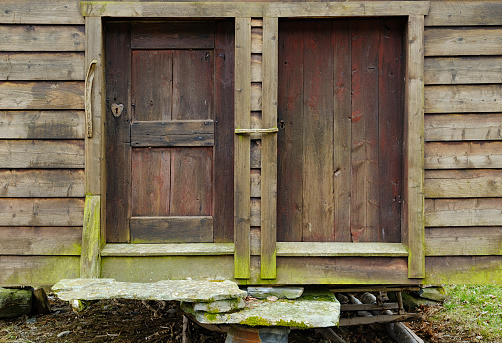 Weathered wooden doors of an old barn provide a glimpse into pastoral life from days past.