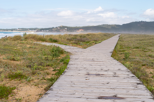 wooden path with two exits, one towards the mountains and the other towards the sea. Copy space.