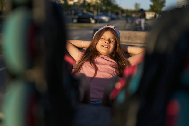Fitness in modern concrete environments. Beautiful girl is relaxing on sun after riding roller skates.
