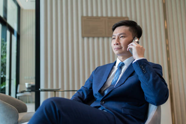 istock Businessman Checking Phone in Modern Lounge Area 2149701895