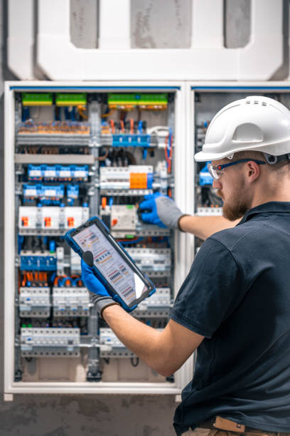 istock Electrician with tablet adjusting circuitry at junction box. 2149705289