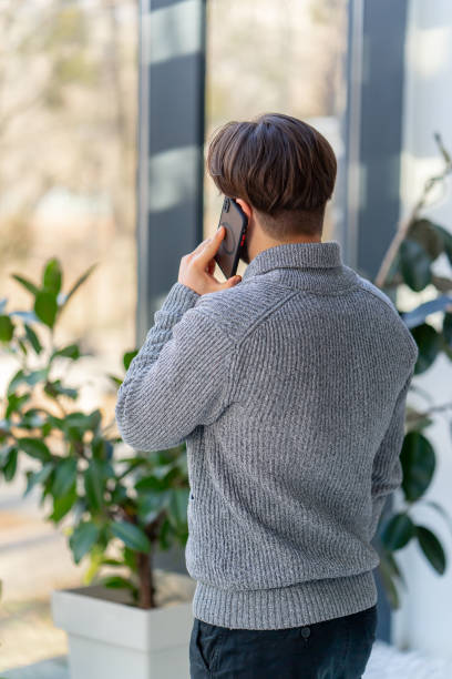 istock a young guy with a beard an office worker stands near the window and has business conversation 2149707097