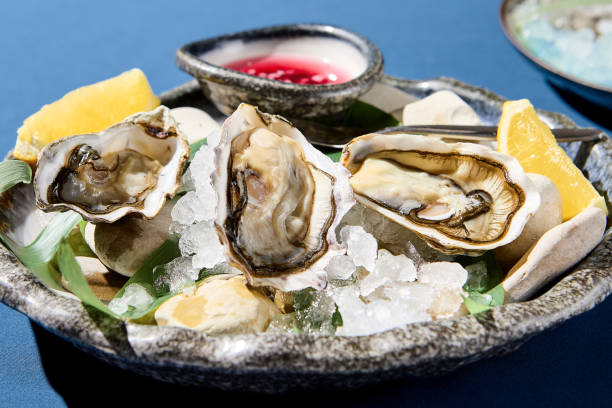 istock Closeup horizontal view of fresh oysters with lemon on ice, an upscale restaurant dish presentation 2149707488