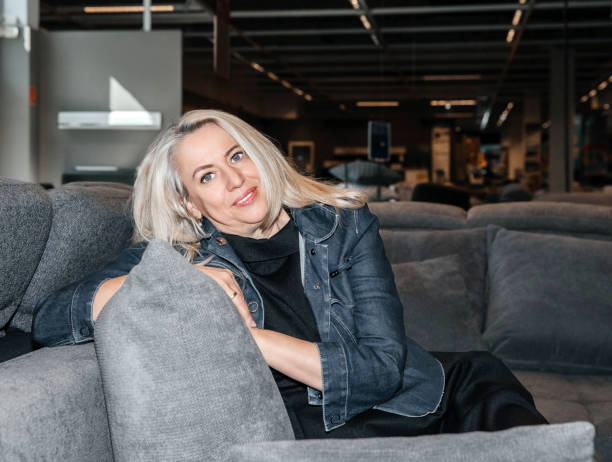 istock Joyful Silver-Haired Lady in a Dark Denim Jacket Nestled on a Charcoal Sofa, Lifestile Concept 2149707935