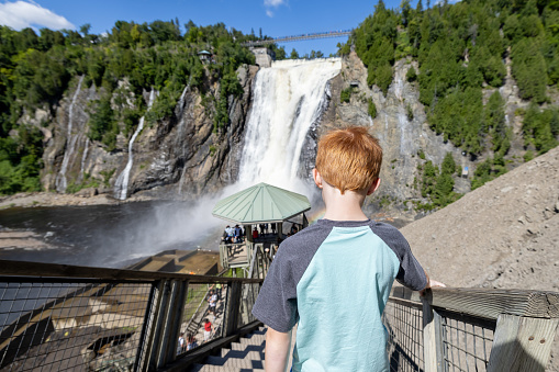 Young Boy going down the stairs at Montmorency Falls in Summer, Quebec City, Canada.