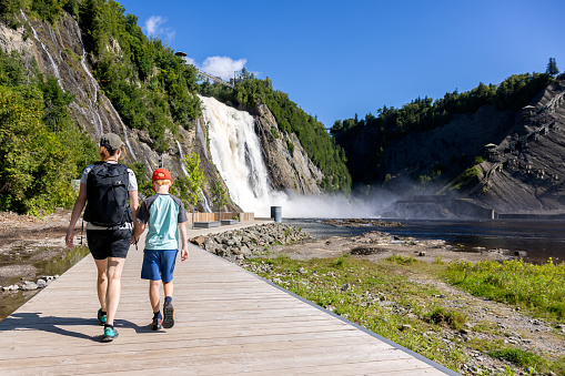 Mother and Son walking on the footbridge at Montmorency Falls in Summer, Quebec City, Canada.