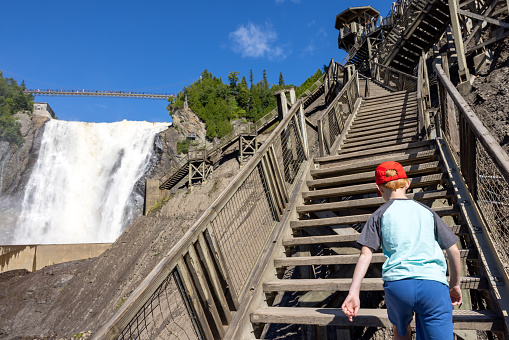 Young Boy climbing stairs at Montmorency Falls in Summer, Quebec City, Canada.