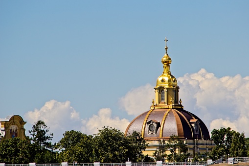View of the magnificent dome of the chapel of the Grand Duke s tomb, gilded decorations in the Baroque style, dome and Orthodox cross, details and elements of architecture, city attractions, green plants, sky and clouds, cityscape, travel and tourism, summer.