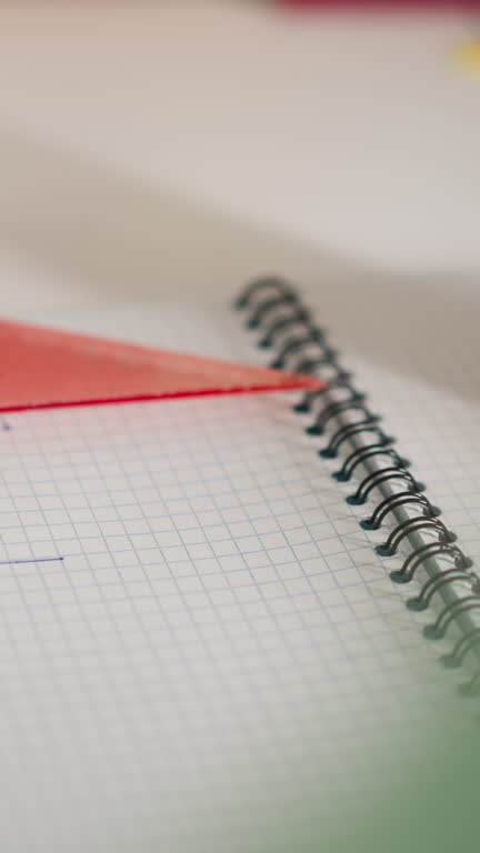 Little student draws triangular shape with ruler and pen