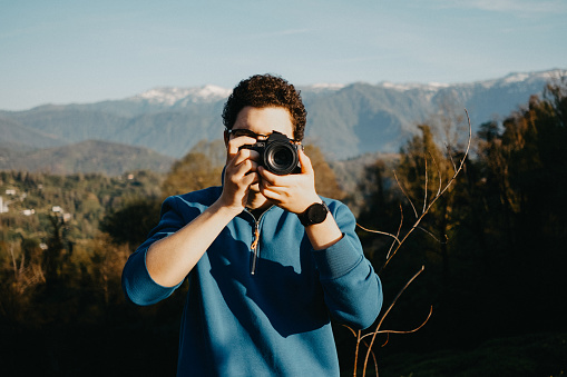Young man taking pictures in nature