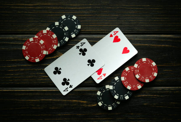 istock Black and red chips and playing cards with a winning combination of one pair on a black vintage table. Low key concept of winning in a poker club or casino 2149712230