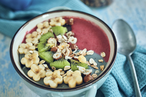 Pitaya Smoothie in Bowl with Kiwi, Banana, Blueberries and Superfoods on Top