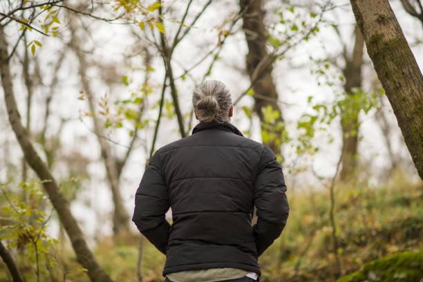 A handsome climber walking among green trees in the forest on a beautiful spring day
