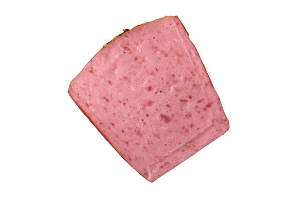 Delicious canned pink ham with salt, spices and herbs on a dark concrete background