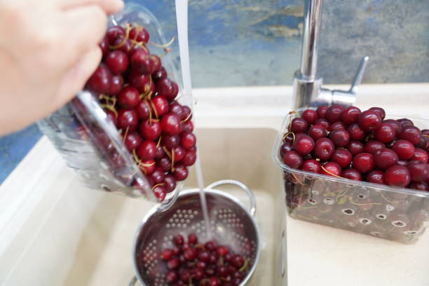 istock fresh cherries, washing cherries in the kitchen, 2149714392