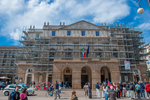 Milan Italy 20 April 2024: Teatro alla scala with scaffolding for facade renovation while people walk by