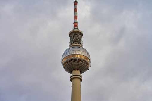 TV tower located at Alexanderplatz in Berlin, Germany against cloudy sky