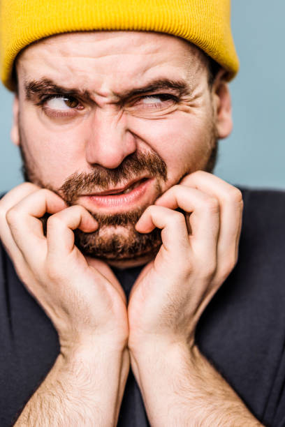 istock Distressed man has beard itch in blue background studio close up portrait. 2149721627