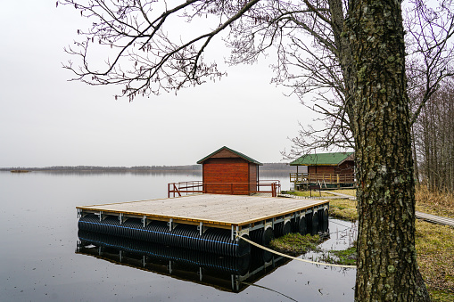 Large floating wooden platforms on pontoons with holiday houses in the lake for leisure and fishing on the water