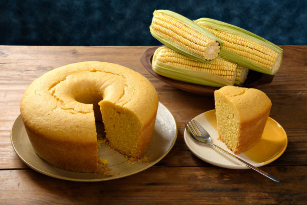 istock Corn cake on a plate on a wooden base, ears of green corn on the table, blue background 2149731663