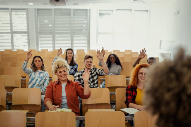 istock College students raising hands to answer teacher's question 2149735508